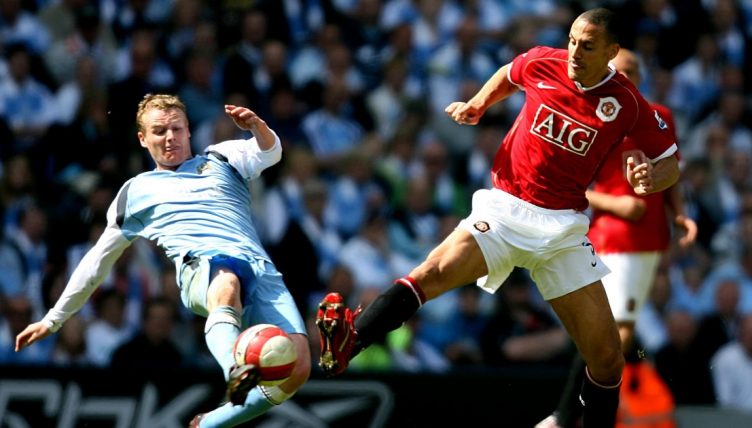 Manchester City's Michael Ball tackling Rio Ferdinand