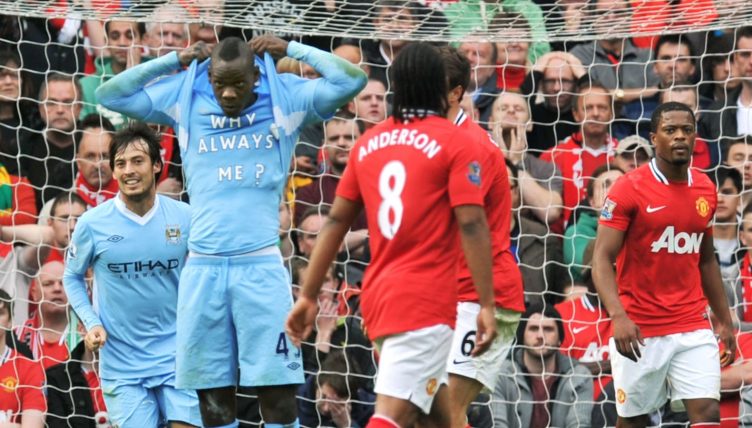 Mario Balotelli unveils his Why Always Me? t-shirt while celebrating his goal in Manchester City's 6-1 Premier League win over Manchester United at Old Trafford, Manchester, 23 October 2011.
