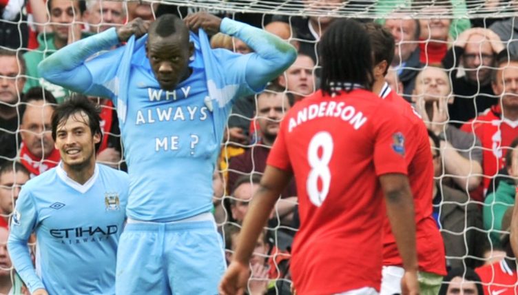 Mario Balotelli celebrates scoring against Manchester United by revealing a t-shirt with 'Why Always Me?' written on it.