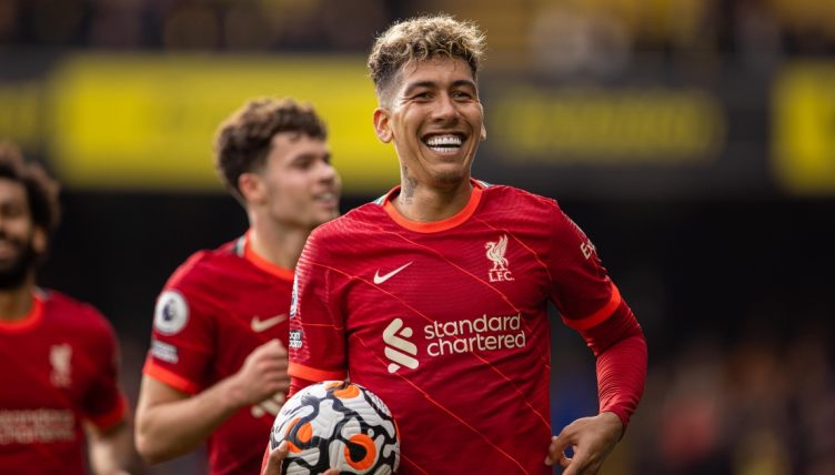 Liverpool's Roberto Firmino celebrates with the match-ball after completing his hat-trick.