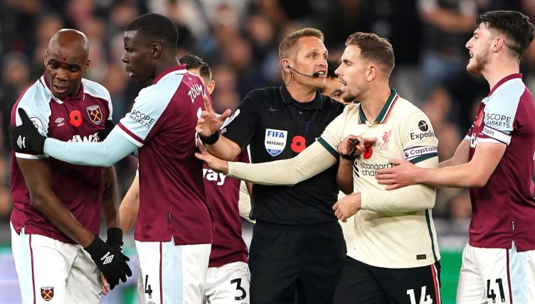 Liverpool and West Ham players surround the referee .