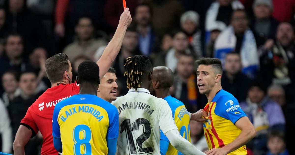 Valencia's Gabriel Paulista, right, is shown a red car by referee Javier Alberola Rojas during the Spanish La Liga soccer match between Real Madrid and Valencia at Santiago Bernabeu stadium in Madrid, Thursday, Feb. 2, 2023.