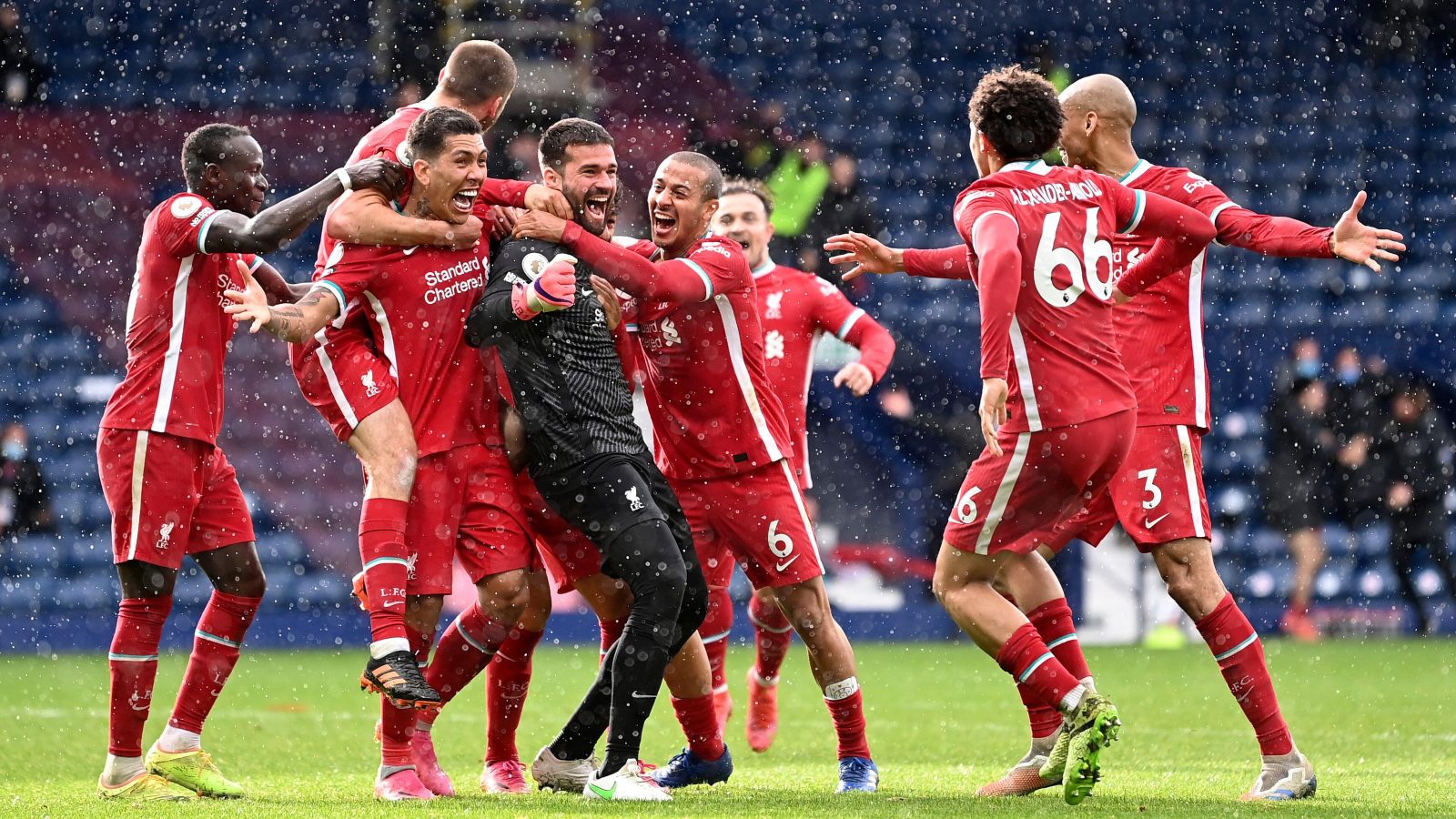 Liverpool's goalkeeper Alisson celebrates with teammates after scoring his side's second goal during the English Premier League soccer match between West Bromwich Albion and Liverpool at the Hawthorns stadium in West Bromwich, England, Sunday, May 16, 2021.