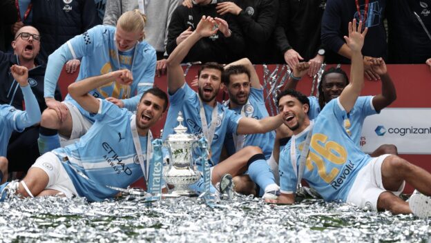Manchester City players pose with the winner's trophy after the English FA Cup final soccer match between Chelsea and Manchester City in London, Saturday, May 16, 2026.