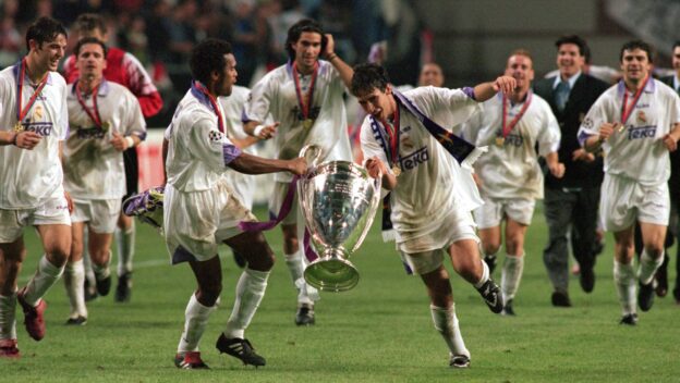 Real Madrid's Christian Karembeu (left) holds the trophy with teammate Raul (right) as they celebrate winning the match